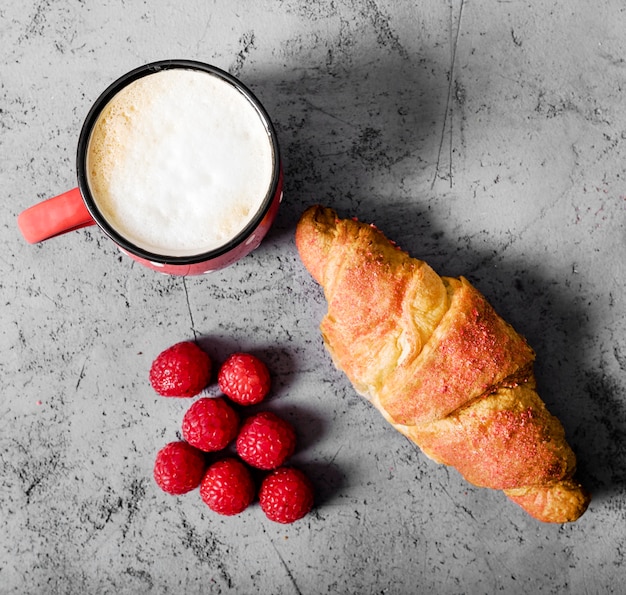 Free photo top view raspberries and croissant