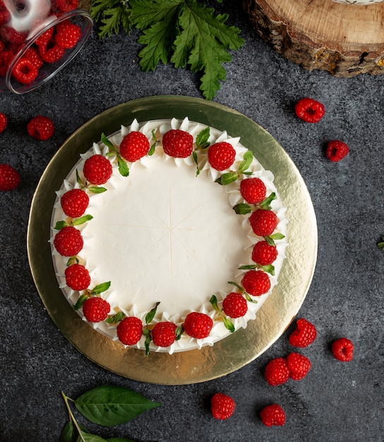 Free photo top view of raspberry cake decorated with white cream raspberries and mint leaves