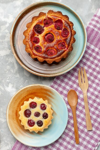 Top view raspberry cake delicious with little cake on the grey-light desk cake pie bake fruit sweet