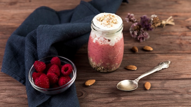 Free photo top view raspberry smoothie on wooden table