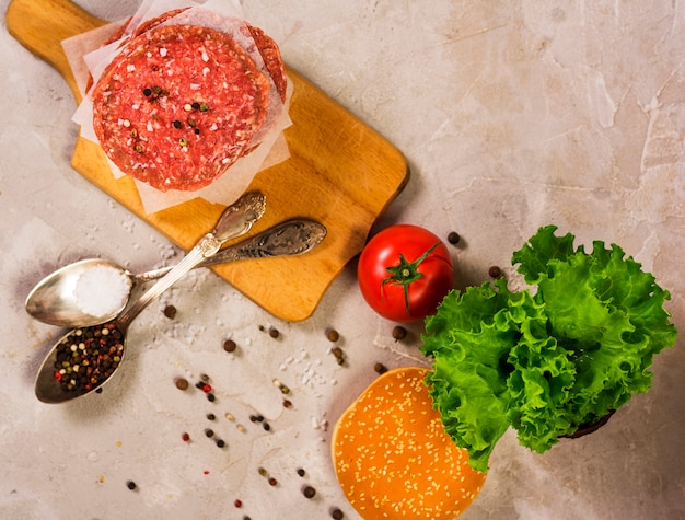 Free photo top view raw burger meat on a wooden table