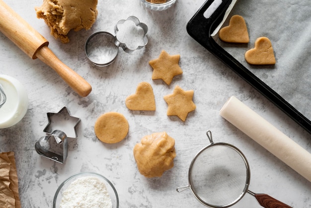 Free photo top view raw cookies with cutting shapes