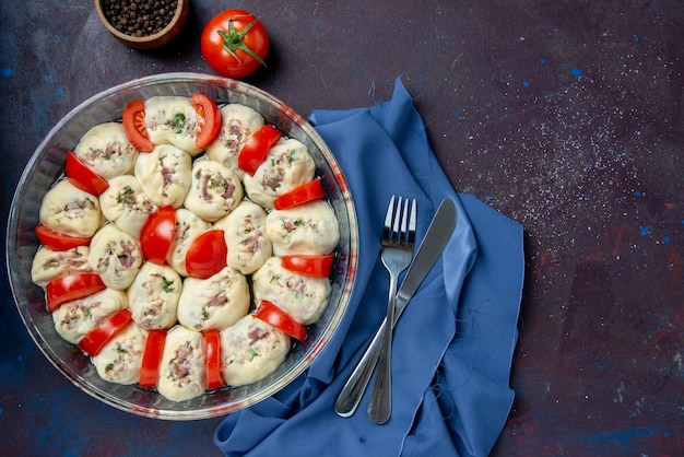 Free photo top view raw dough pieces with ground meat and tomatoes on the dark meal kitchen dish cuisine photo color food salad