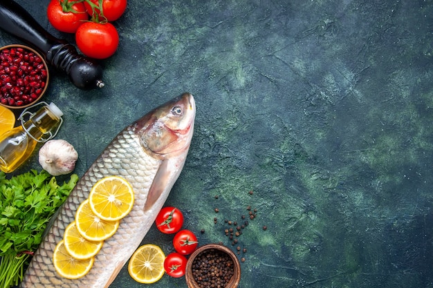 Free photo top view raw fish pepper grinder tomatoes on table with free space