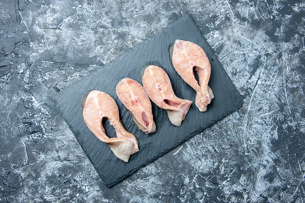 Free Photo top view raw fish slices on black board on table free space