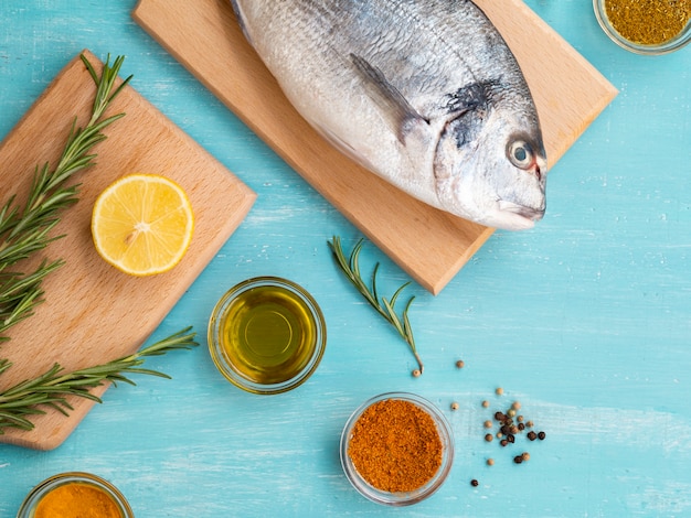 Free photo top view raw fish on a wooden board