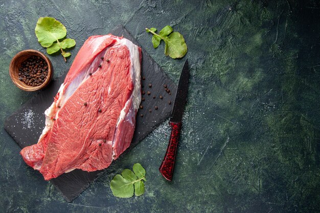 Free Photo top view of raw fresh red meat on cutting board pepper and knife on green black mix colors background