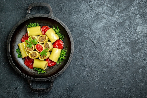 Top view raw italian pasta with meat greens and tomato sauce inside pan on a dark desk pasta dough meal food