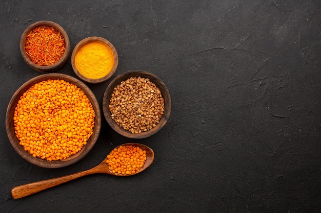 Top view raw lentil with buckwheat on dark space