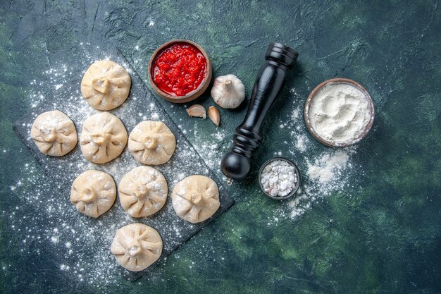 Top view raw little dumplings on dark table dough pie cake meat dish dinner fresh