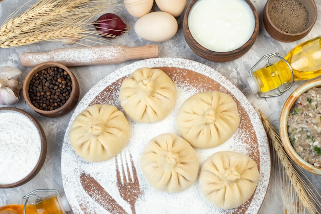 Top view raw little dumplings with seasonings and eggs on a white background pie color food bake cake dough salad meat