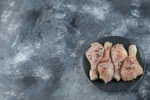 Free photo top view of raw marinated chicken legs on grey background.