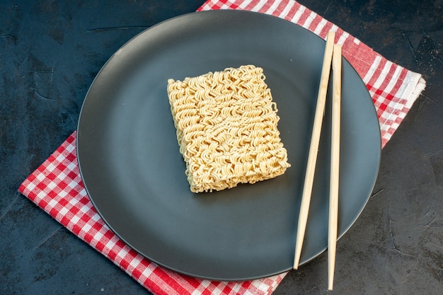 Top view raw noodles with sticks on dark wall