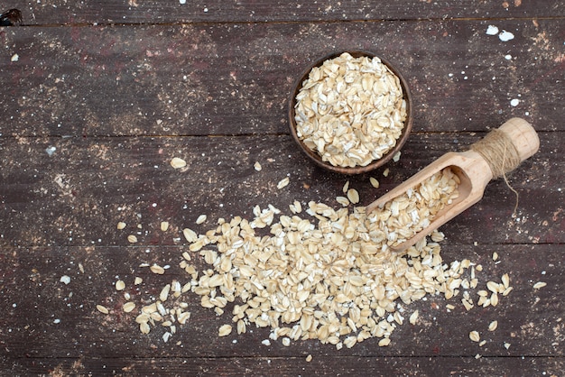 Top view raw oatmeal light colored on brown, crackers snack bread dried meal useful health breakfast