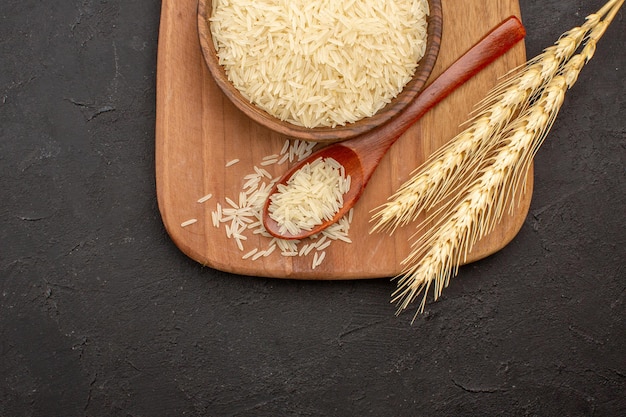 Top view of raw rice inside plate on grey surface