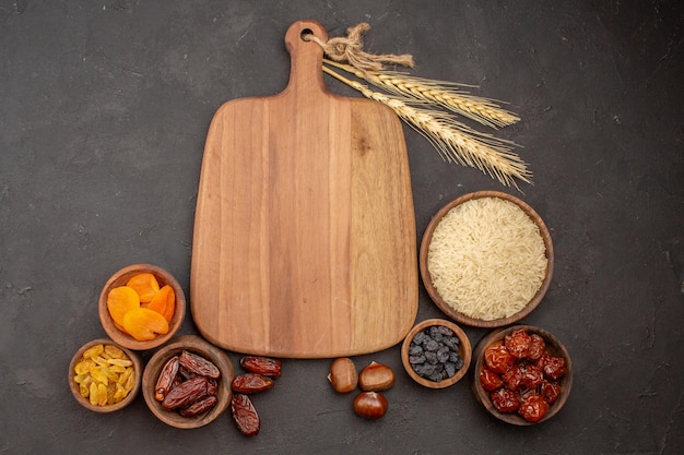 Top view of raw rice with different raisins on grey surface