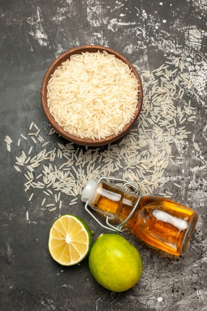 Free Photo top view raw rice with lemons and oil on a dark surface raw food fruit color