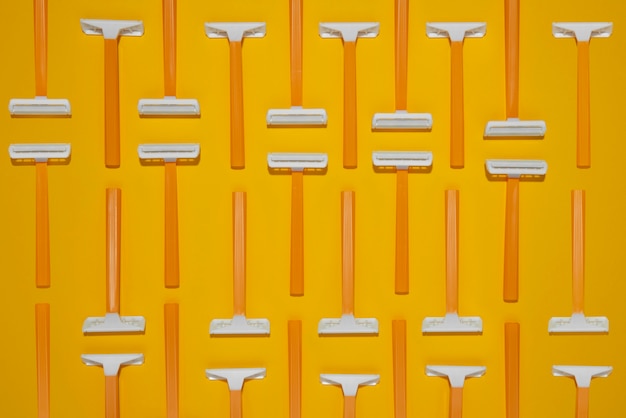 Free photo top view razor blades with yellow background