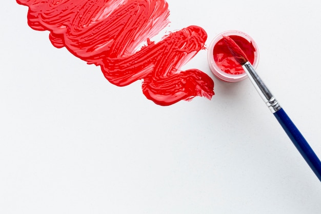 Free photo top view of red aquarelle with brush