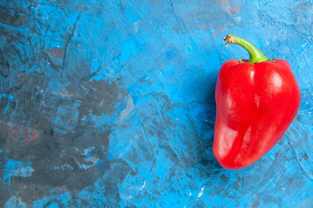 Top view of red bell-pepper on blue surface