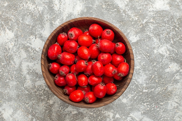 Free photo top view red fruits inside plate on white background