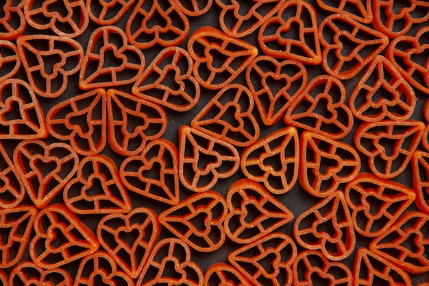 Top view red heart italian pasta on dark ground