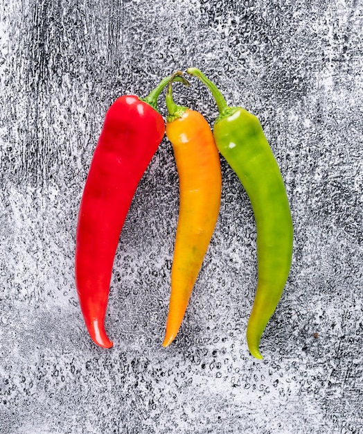 Top view red yellow and green chili pepper on gray stone  vertical