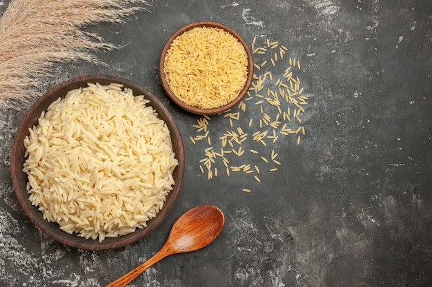 Top view of rice meal and uncooked rice with spoon