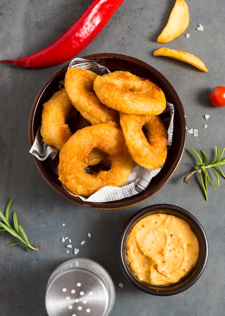 Top view of ring fries in bowl with salt and mustard