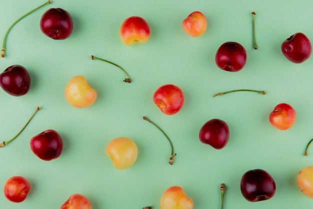 Top view of ripe rainier cherries and red cherries isolated on mint color