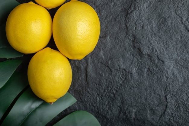 Free photo top view of ripe yellow lemons over black background