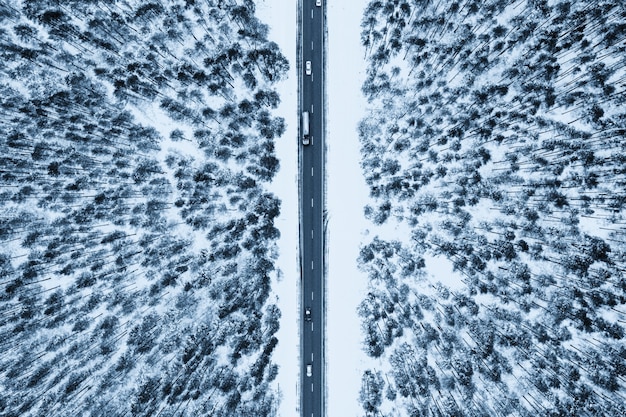 Top view of a road surrounded by snow and fir trees