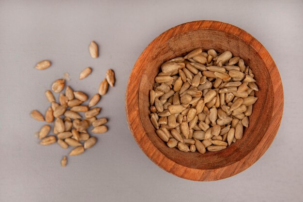 Top view of roasted shelled sunflower seeds on a wooden bowl