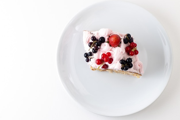 Top view roll slice with cream blueberries and strawberry inside white plate on the white background cake biscuit sweet color