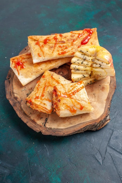 Top view rolled dough pita sliced with sauce on dark blue desk