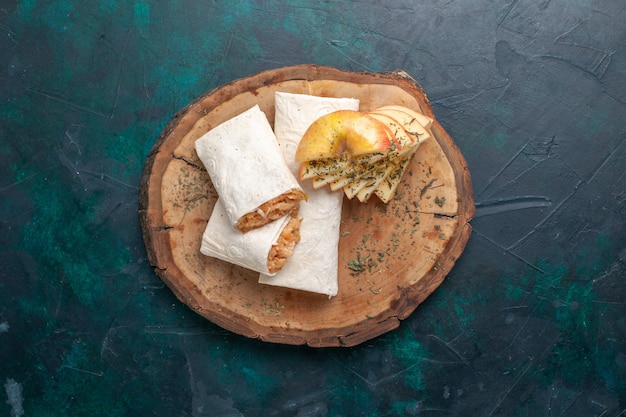 Top view rolled dough with meat filling on dark-blue background