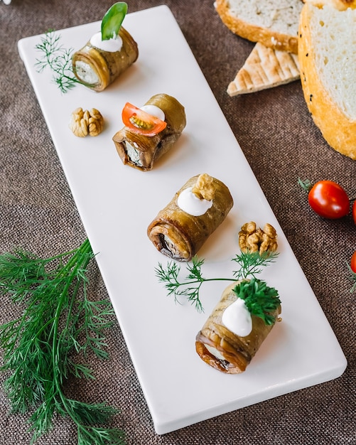 Top view rolled eggplant with stuffing herbs and tomatoes