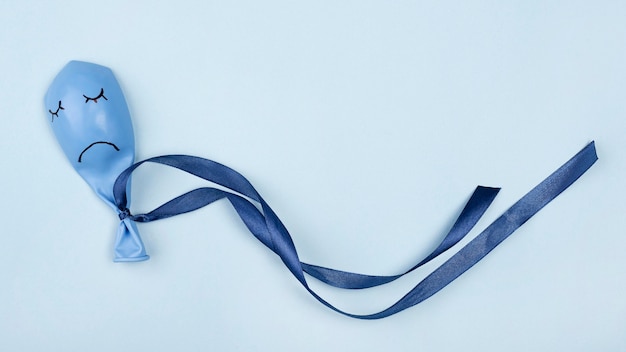 Free Photo top view of sad blue monday balloon with ribbon