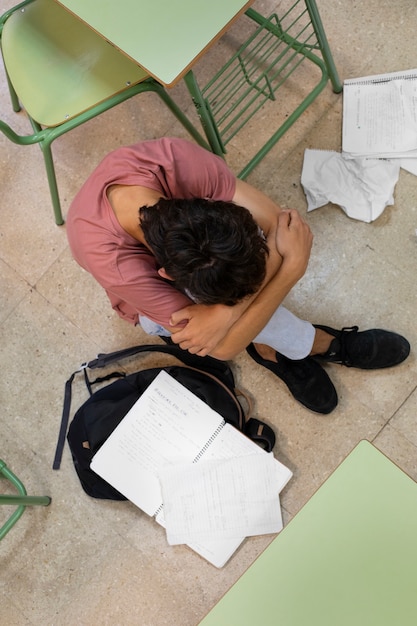 Top view sad boy in classroom