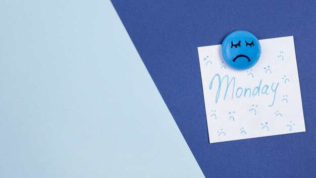 Top view of sad face with copy space and sticky note for blue monday