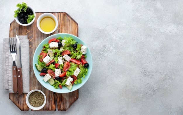 Free photo top view salad with feta cheese on cutting board with copy-space