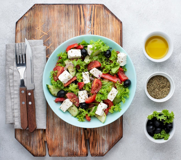 Free photo top view salad with feta cheese on cutting board with olives