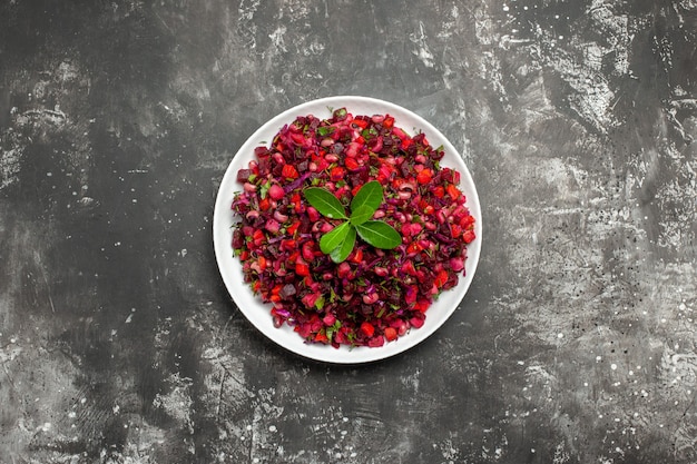 Top view salad with red vegtable in a white dish on grey background