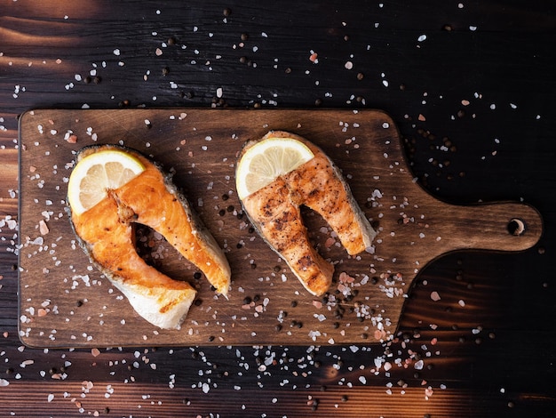 Free photo top view of salmon rings arranged on a wooden bottom and pressed with salt