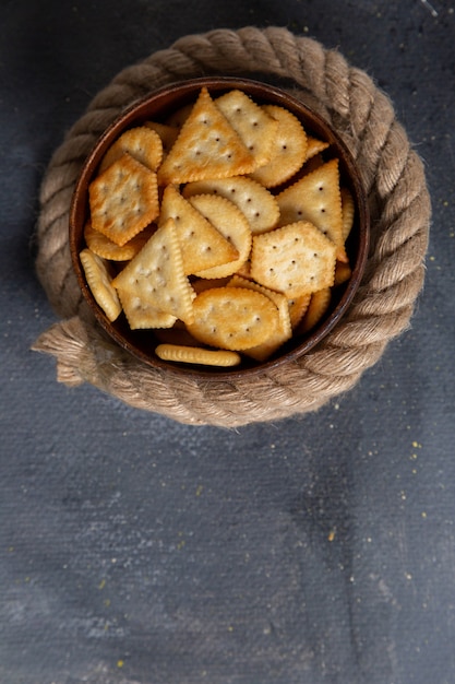 Top view salted crackers tasty with ropes on the grey desk snack crisp cracker photo