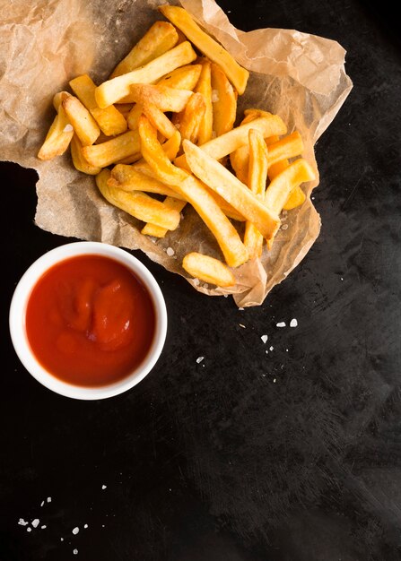 Top view of salted french fries with ketchup