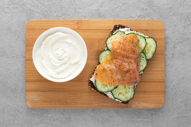 Top view sandwich with cucumbers and salmon on cutting board