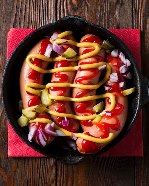 Free Photo top view sausages in pan with sauces and onion