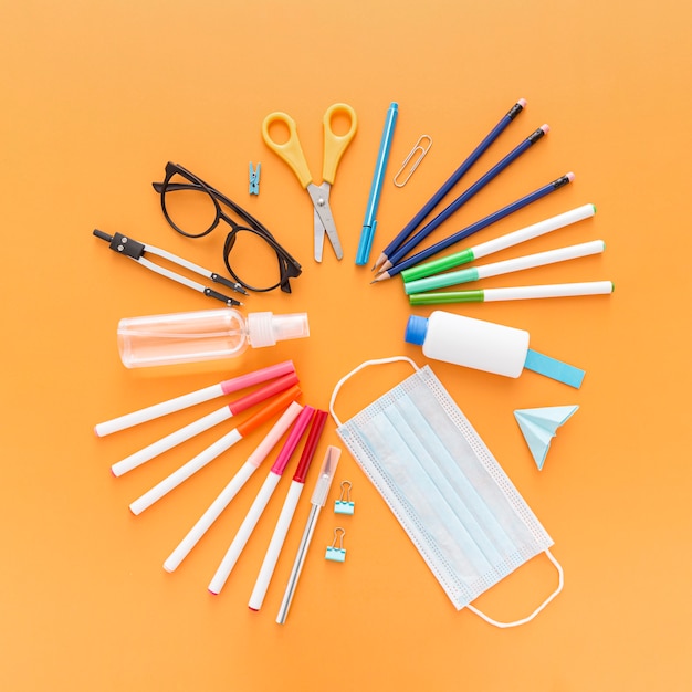 Free photo top view of school supplies with face mask and pencils