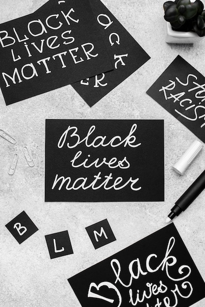 Free photo top view of selection of cards with black lives matter and pen